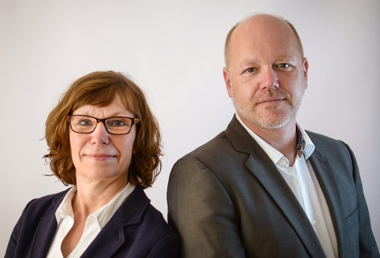 Ute & Sven Carstens Porträt von zwei Personen, einer Frau und einem Mann, beide professionell gekleidet.